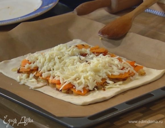 На тесто, отступая от краев на пару сантиментов, выложить лук и обжаренную тыкву, сверху посыпать натертым сыром.