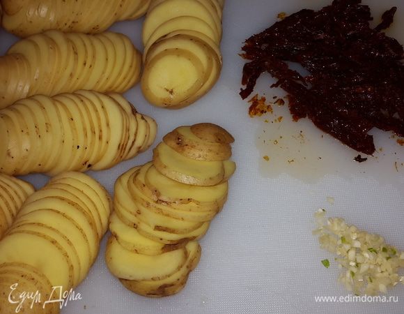 Картофель моем, обсушиваем и режем на пластики толщиной 1-2 мм. Томаты режем соломкой, чеснок мелко рубим.