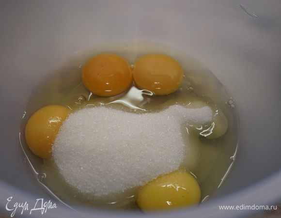 Приготовим бисквит. Включить разогреваться духовку до 200 ° С. Противень застелить пергаментом, смазанным маслом. 
Взбейте 2 яйца, 2 яичных желтка и сахар в течение 5-7 минут до увеличения массы в 2-3 раза.
