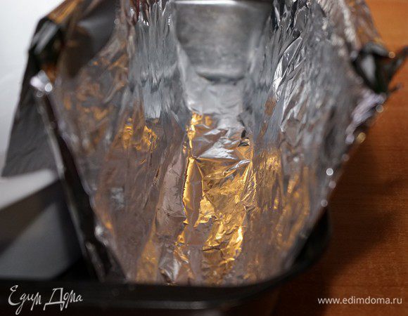 Пока остывал корж, я соорудила форму для рулета. Я взяла большой подарочный пакет из плотного картона, обернула его фольгой, изогнула его и установила в большую форму, подперев сбоку, чтобы ширина сверху между стенками была около 8-9 см (т.е. 7 см донышко рулета + толщина коржа). Таким образом,  получилась заготовка для рулета формы «полутруба».