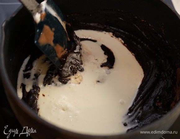 Добавить сливки и снова довести до кипения. 
Снять с огня и добавить отжатый желатин. Хорошо размешать и процедить глазурь через сито. Дать остыть до комнатной температуры.