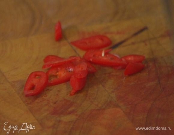 Перец чили, удалив семена, мелко порезать и добавить в кастрюлю.