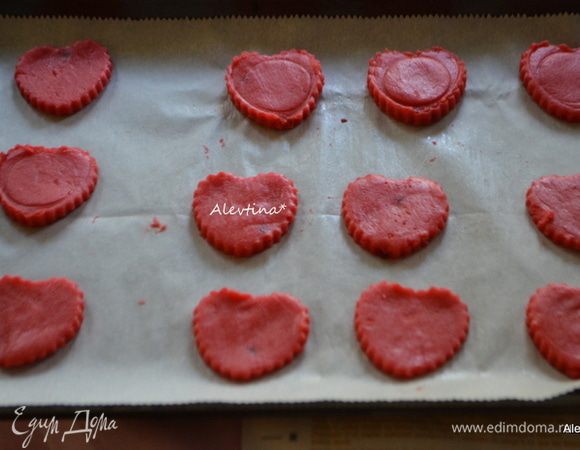 Вырезать любой формочкой фигуры, перенести на бумагу и, убрав лишнее тесто, на противень. Также поступить со вторым куском теста.
