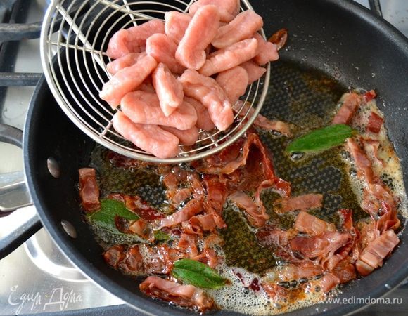 К грудинке в сковороду добавить листья шалфея и сразу же выложить готовые ньокки. 