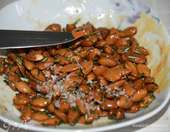 Орехи посыпать травами, равномерно перемешать, посыпать морской солью и щепоткой перца чили. 