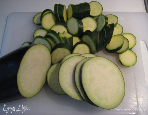 Порезать баклажаны и цукини кружочками, шампиньоны разрезать пополам.