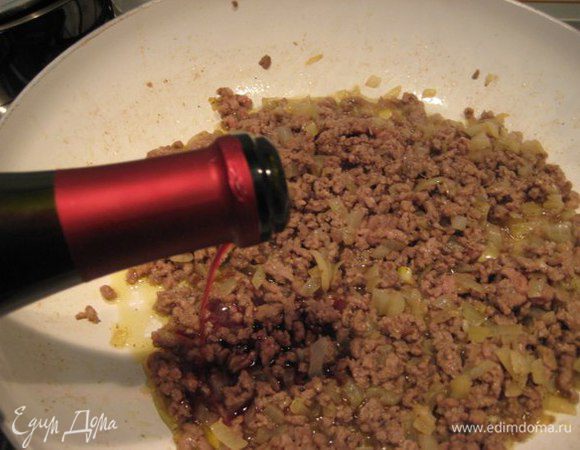 Добавить к луку фарш, обжарить, разминая лопаткой, чтобы не было комочков. Посолить, поперчить. Влить красное вино, дать алкоголю выпариться. Выключить сковороду, дать начинке остыть.