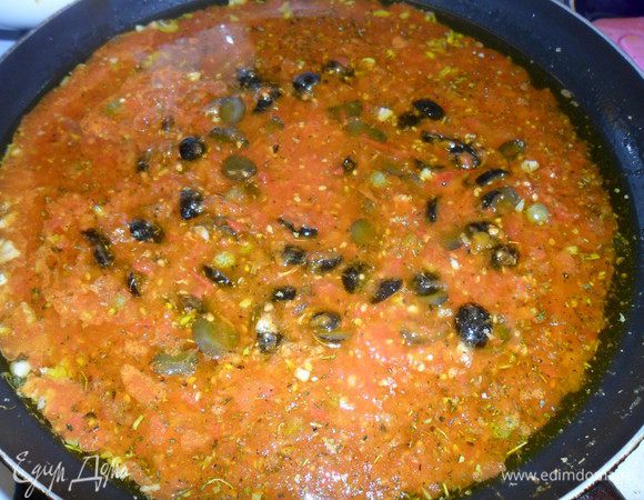 Добавляем томаты, каперсы, оливки, базилик и орегано. Накрываем крышкой и тушим 15 минут. Добавляем зелень и тушим еще 5 минут.