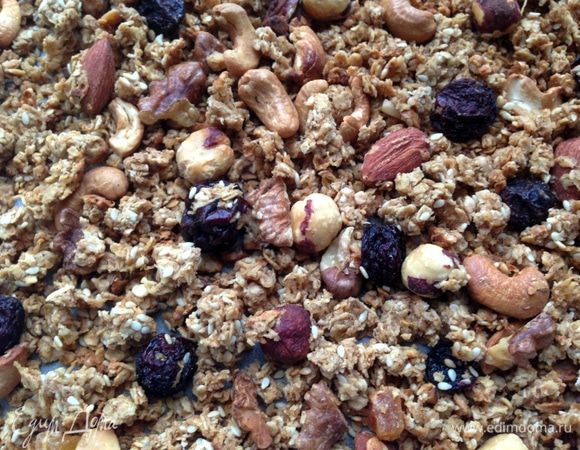 Духовку разогреть до 180 градусов. Выложить полученную массу на выстеленный пергаментом противень и хорошо разровнять. 
Запекать 35-40 минут. Каждые 15 минут противень доставать из духовки и хорошо перемешивать гранолу. Это делается для того, чтобы она подрумянилась равномерно и получилась рассыпчатой.