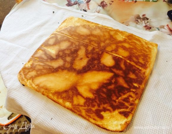 Когда бисквит готов, достаем из духовки, кладем сверху чистое кухонное полотенце и переворачиваем противень, чтобы наш бисквит полностью оказался на полотенце. 