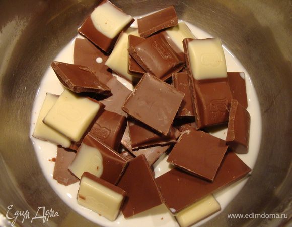 Шоколад для прослойки поломать. Добавить сливки, растопить. Можно на слабом огне или в микроволновке. Я добавила немного белого шоколада.