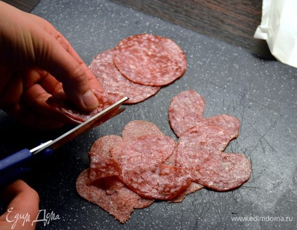 За это время вырезать из кружочков салями сердечки. Просто сложите каждый кружок пополам и придайте ему форму капли. Затем откройте, и у Вас получится...