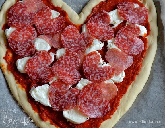 Сверху выложить кусочки моцареллы и салями.