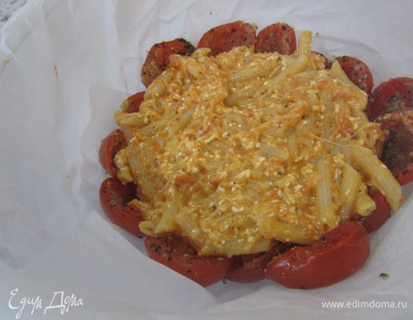 Огнеупорную форму проложить пекарской бумагой. На дно и бока формы выложить подготовленные помидоры в один слой, срезом внутрь. Заполнить макаронами.