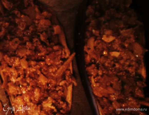 Готовую начинку раскладываем по баклажанным лодочки. 