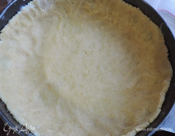 Песочное тесто распределяем по форме диаметром 26 см, дно предварительно выстилаем пергаментом, формируем высокие бортики.