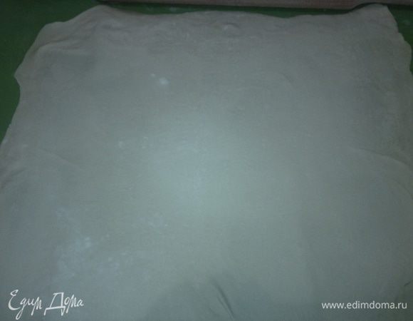 Готовое слоеное бездрожжевое тесто разморозить. Присыпать стол мукой и раскатать тесто. Желательно раскатывать тесто в одну сторону,чтобы оно не порвалось.