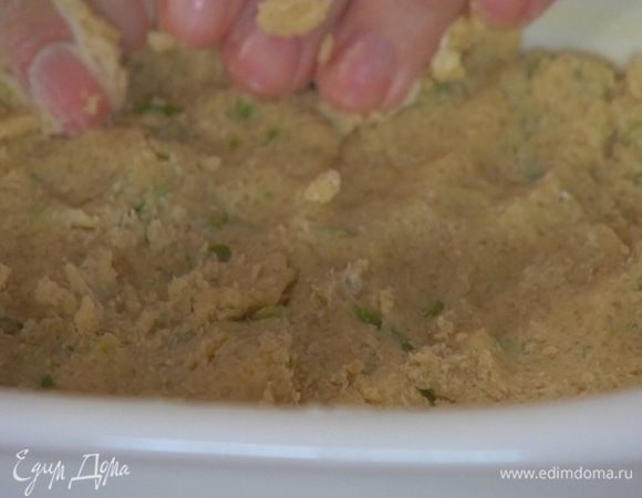 Керамическую жаропрочную форму смазать оставшимся сливочным маслом, выложить тесто и распределить его ровным слоем, плотно прижимая руками.