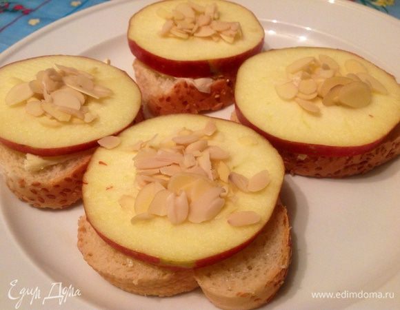 У меня из одной пресной булочки с кунжутом получилось 8 кружков, все намазала сливочным маслом, посыпала сахаром, на 4 кружка положила по кружку яблока с вырезанной серединкой, в которую насыпала миндаля.