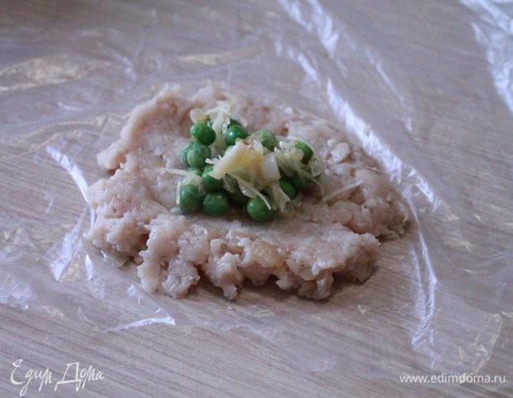 Фарш разделить на равные порции как для котлет. Раскладываем на ладони кусочек фарша в лепешку и на нее выкладываем пол чайной ложки начинки. Если на ладони вам не удобно, можно взять целлофан, на него положить фарш, придать форму лепешки и положить начинку. Свернуть в котлетку, помогая себе целлофаном. 