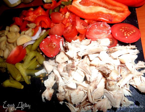 Отварную куриную грудку потрошим на волокна и разрежем на кусочки.