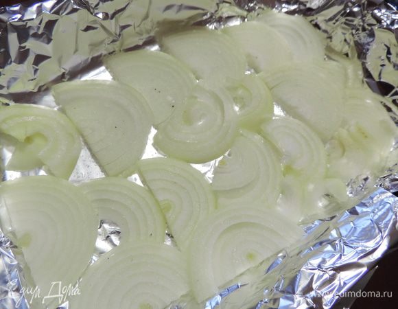 Стеклянную или керамическую форму предварительно смазать сливочным или растительным маслом, обычную - застелить фольгой в два слоя.
Выкладываем слой репчатого лука, нарезанного полукольцами. Немного солим его.