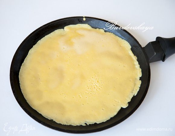  Раскалить блинную сковороду, смазать маслом. Вылить тесто на сковороду (чуть меньше стандартного половника) и распределить тесто по сковороде, наклоняя ее. Жарить блины следует на среднем огне. Когда блин с одной стороны равномерно покроется пузырьками - перевернуть его. Со второй стороны готовить блин всего 10-15 секунд.