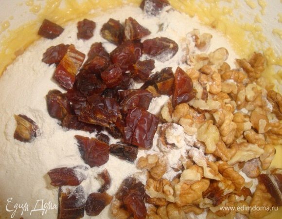 Добавляем в эту смесь рубленные орехи, финики и 0,5 ст. муки. Хорошо перемешиваем. 