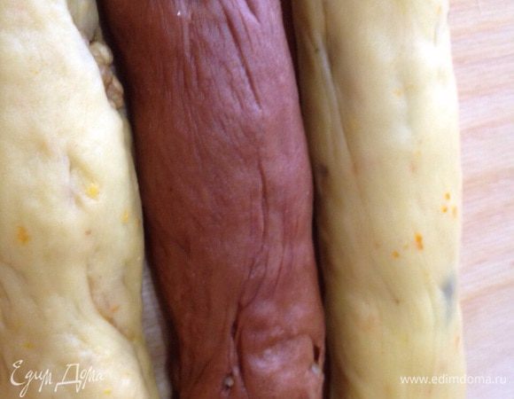 Подошедшее апельсиновое тесто разделяем пополам. Сформируем 2 жгута длиной 30 см. Из шоколадного тесто сформируем 1 жгут. Выложим жгуты на смазанный маслом противень - шоколадный жгут в центре. 