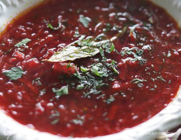 Готовую овощную заправку выложить в кастрюлю с бульоном, посолить, поперчить, добавить зелень, довести борщ до кипения и снять с огня. Подавать со сметаной.