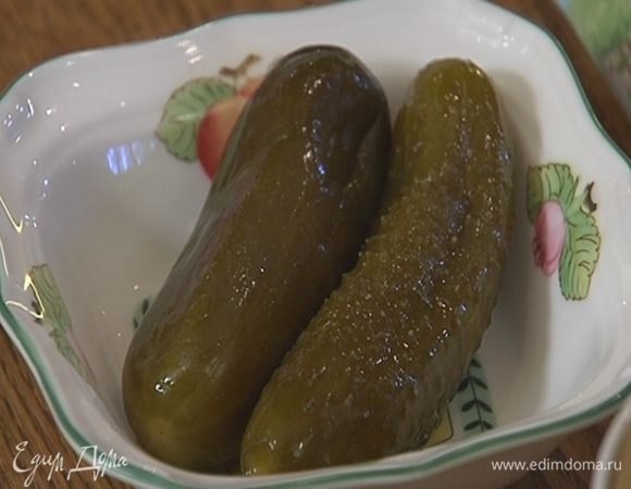 Соленые огурцы очистить от кожуры, нарезать мелкими кубиками, выложить в небольшую кастрюлю, добавить немного воды и потушить на маленьком огне.