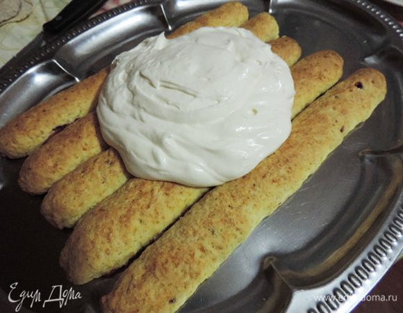 Приступаем к сборке. Остывшие трубочки обрезаем, чтоб у них была одинаковая длина. На блюдо выкладываем 5 трубочек плотно друг к дружке.
Щедро смазываем кремом, его жалеть не нужно, иначе торт получится суховатым.