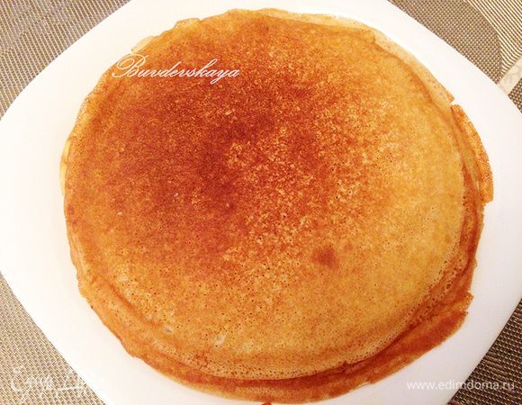 Когда край блина начнет зарумяниваться, его необходимо перевернуть на другую сторону и готовить недолго, примерно 20–30 сек. Выложить блин на тарелку и смазать растопленным сливочным маслом. Подавать блины горячими! 