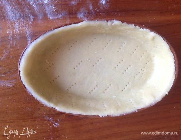 Достать тесто из холодильника, раскатать его на присыпанной мукой поверхности, перенести корж в форму, разровнять, наколоть вилкой. Сверху положить бумагу для выпечки и насыпать фасоль (или любую другую крупу), отправить в духовку запекаться на 15 мин при 180 градусах.