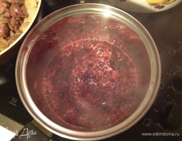 Клюкву засыпать сахаром, добавить воды, довести до кипения, убавить огонь до среднего и дать покипеть, пока обжаривается печень.