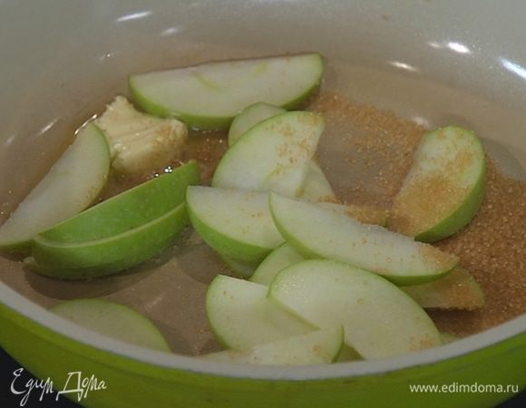 Разогреть в сковороде сливочное масло, всыпать оставшийся сахар и выложить дольки яблока.