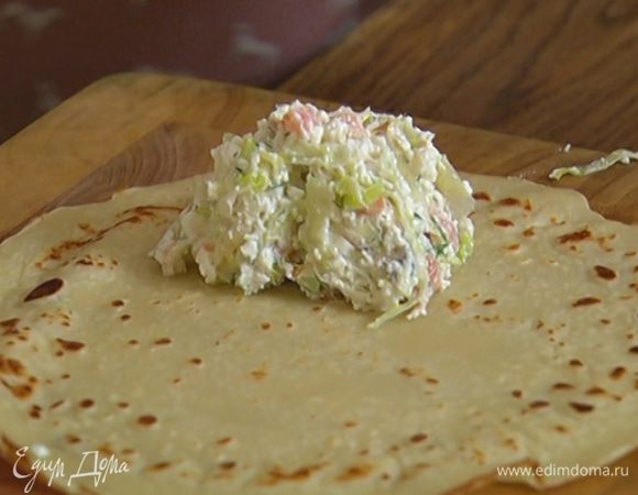 На край готовых блинов выкладывать понемногу начинки и сворачивать их рулетиками.