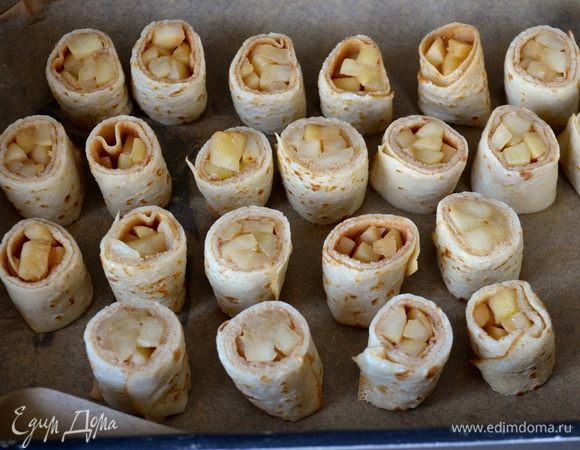 Противень застелить пекарской бумагой. Рулетики из блинов нарезать на кусочки шириной 1-1.5 см. Выложить на противень.