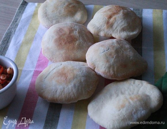 Аккуратно достать горячий противень и переложить на него вместе с бумагой лепешки. Выпекать по 4 минуты с каждой стороны. Не передержите, пусть вас не смущает бледный вид лепешек, это нормально. Вы увидите как лепешки почти мгновенно начнут надуваться. 