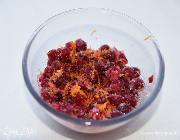 Растопить сливочное масло. Остудить. 
Натереть на мелкой терке цедру c апельсина. В миске смешать клюкву, сахар и цедру. У меня была гигантских размеров клюква, поэтому я её, слегка подтаявшую, порезала пополам.