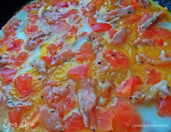 Размещаем рыбку между овощами. Сверху можно посыпать половиной сыра.