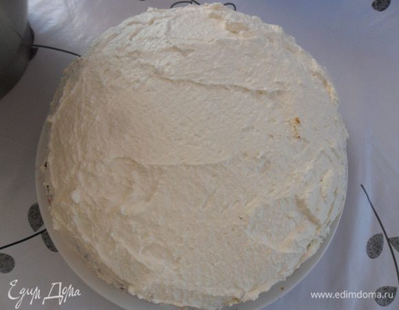 Накрыть второй половиной бисквитного коржа. Выложить еще слой сливок и покрыть сливками края торта. 