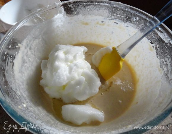 Осторожно с помощью лопатки вводим в тесто белки. Круговыми движениями снизу вверх.