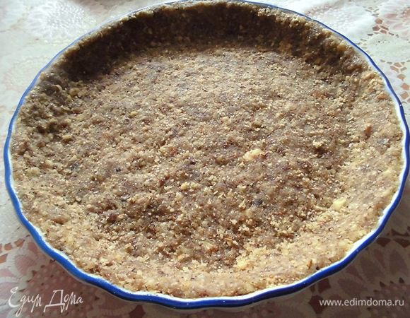 Изюм и грецкие орехи прокрутить через мясорубку. Взять форму (у меня керамическая, диаметром 21,5 см) и выложить туда основу, сделать бортики. Убрать в холодильник, пока буде готовиться начинка. 