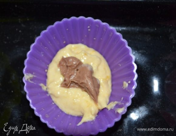 Тесто выложить в форму для кексом на 1/3 формы, далее положить чайную ложку начинки.