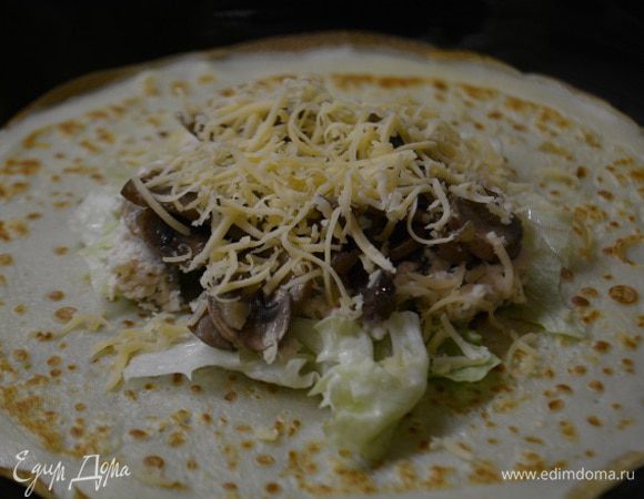 Сборка: на середину готового блинчика уложить лист айсберга, куриную начинку, грибную начинку и посыпать сыром.