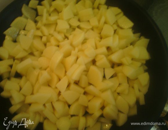 Выложить на сковороду с оливковым маслом, накрыть крышкой. Жарить на сильном огне первые две минуты, периодически перемешиваем. Снижаем огонь на минимум и готовим ещё 20 минут. За это время нарезать лук, чеснок, петрушку. 