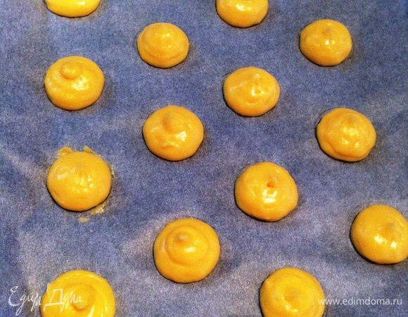 Отсаживаем на противень заварное тесто (круги просвечивают через пергамент, поэтому легко это сделать).