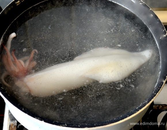В кастрюлю налить воду и дать закипеть. Положить столовую ложку соли. Варить тушки кальмаров буквально по 1 минуте, помещая их поочередно в кастрюлю с кипящей водой.