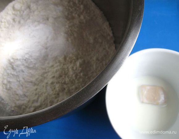 Насыпать муку в  миску ( кастрюлю).  Добавить  сахарную пудру и соль. Смешать.
Влить дрожжи, смешанные с молоком (чуть выше температуры тела), перемешать. Добавить кусочки масла. Перемешать.
Добавить яйцо, желток, немного теплой воды, перемешать, добавлять воду  до нужной консистенции теста. Вымесить руками эластичное тесто. Вначале тесто будет липким, затем будет хорошо отставать от рук. Это занимает примерно 10 – 15 минут.